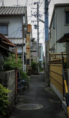 an alley way with buildings and power lines above it