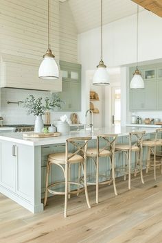 a large kitchen with wooden floors and white walls, along with blue cabinets and counter tops