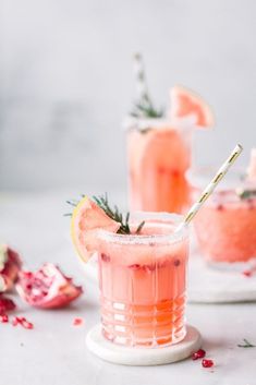 two glasses filled with pink lemonade and garnished with rosemary