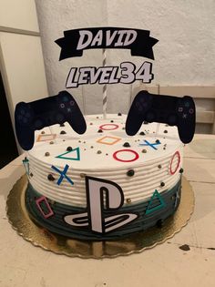 a birthday cake with two video game controllers on it and the name david level34