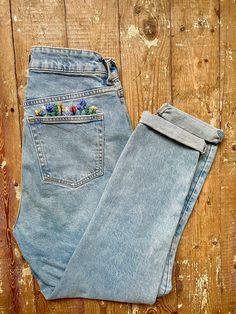 a pair of blue jeans sitting on top of a wooden floor next to each other