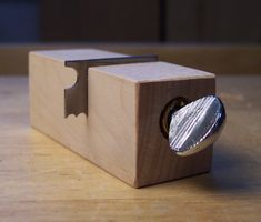 a wooden box with a metal object in the middle on top of a wood table