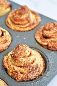 cinnamon rolls in a muffin tin with powdered sugar on top