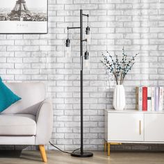 a living room with white brick walls and a floor lamp next to a couch in front of a bookcase