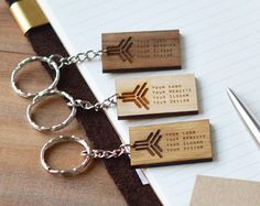 three wooden keychains with arrows engraved on them