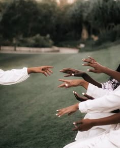 several people reaching out their hands to each other