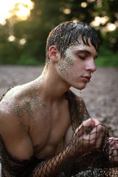 a man covered in sand sitting on the ground