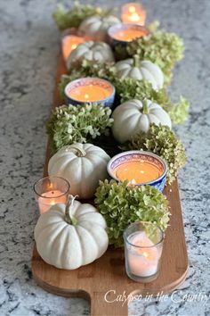 long charcuterie wooden bread board decorated with white pumpkins, hydrangeas and blue and white candles White Fall Decor, Fall Table Runners