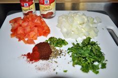 the ingredients to make this dish are displayed on a cutting board, including onions, peppers and seasonings