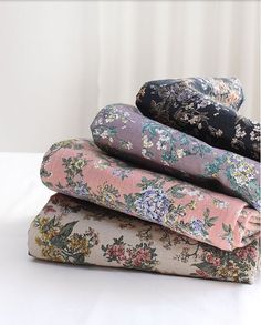 a stack of four different colored floral fabrics