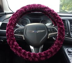 the steering wheel cover is covered in pink fuzzy yarn