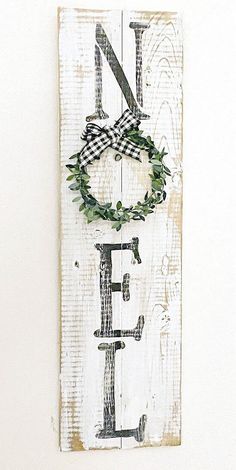 a wooden sign with a wreath hanging on it's side that says no e