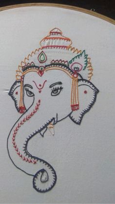 an elephant painted on the side of a white wall with colorful thread work and tassels