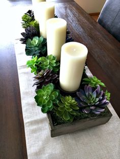 a table with candles and succulents on it