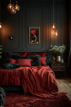 a bedroom with dark walls, red bedding and black furniture in the corner is lit by hanging lights