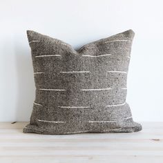 a black and white pillow sitting on top of a wooden table