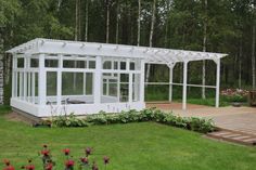 a white gazebo sitting on top of a lush green field