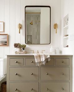 a bathroom vanity with drawers and a mirror above it