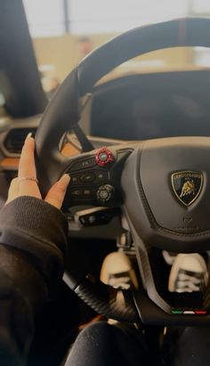 a person driving a car with their hand on the steering wheel