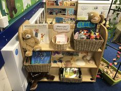 a book shelf filled with books and stuffed animals in front of a blue carpeted wall