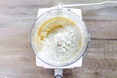 a blender filled with flour on top of a wooden table