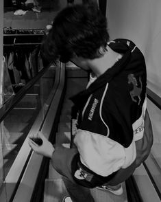 a young man sitting on an escalator looking at his cell phone