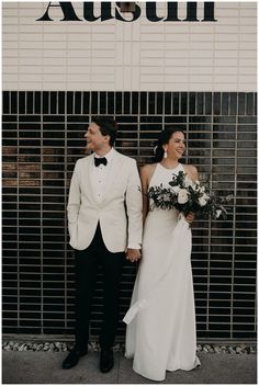 a couple standing next to each other in front of a sign that says austi