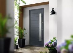 a gray door is next to some potted plants