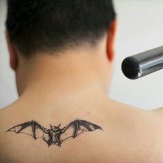 a man with a bat tattoo on his back