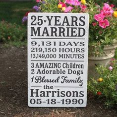 a sign that says 25 years married in front of some flowers and potted plants