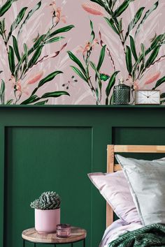 a bedroom with green walls and pink flowers on the wall, along with two side tables