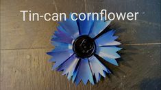 a blue flower with the words tin - can cornflower on it's side