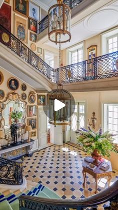 the inside of a house with lots of pictures on the wall and stairs leading up to the second floor