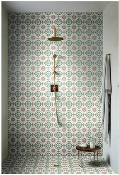 a shower head and hand held shower faucet in front of a floral wallpaper