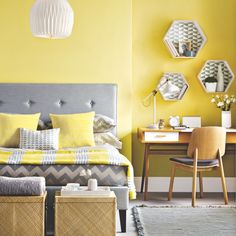 a bedroom with yellow walls and gray bedding, two stools in front of the bed