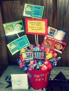 a bucket filled with lots of candy sitting on top of a table next to a sign