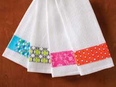 a white towel with colorful patchwork and polka dots hanging on a wooden table top