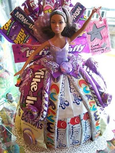 a barbie doll sitting on top of a pile of candy