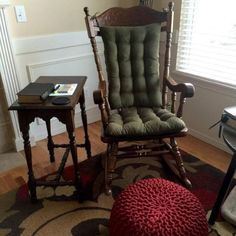 a rocking chair and table in a living room