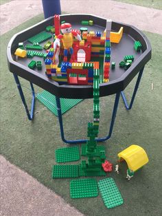 a child's play table made out of legos and other toys on the ground