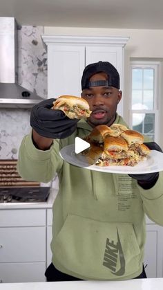 a man holding a plate with sandwiches on it