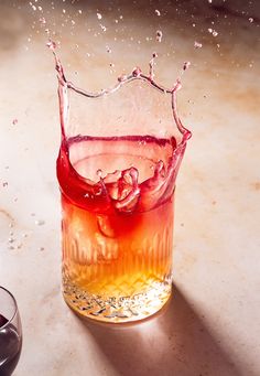 a glass filled with liquid sitting on top of a table