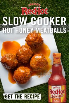 a white plate topped with meatballs next to a bottle of red hot slow cooker