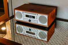 an alarm clock radio sitting on top of a wooden stand next to a mirror in a room