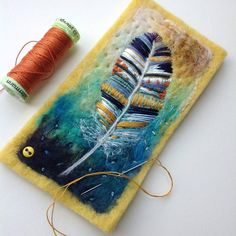 two spools of thread are next to a piece of art