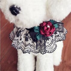 a teddy bear wearing a black and white lace dress with a red rose on it