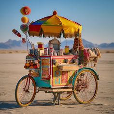 an ice cream cart is parked in the middle of the desert with umbrellas over it