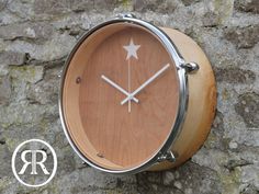 a wooden clock mounted to the side of a stone wall with white stars on it