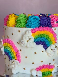 a rainbow cake with white frosting and decorations