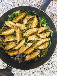 a wok filled with food sitting on top of a counter